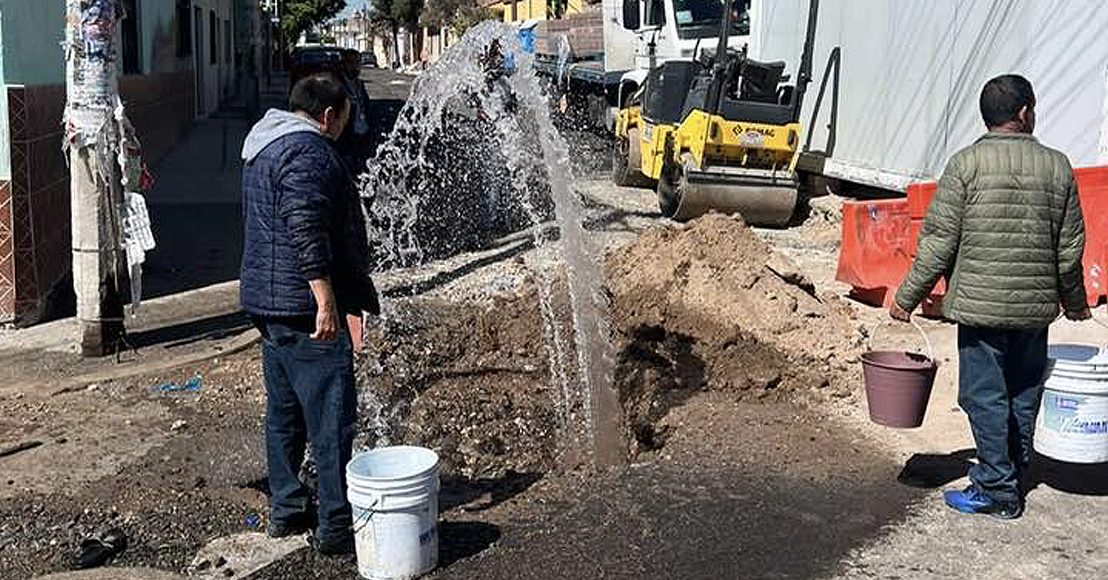 Gente acarrea agua con cubetas de una fuga en Querétaro.